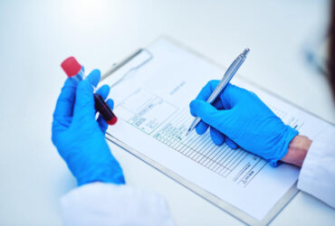 Cropped shot of a scientist recording the results of a blood test